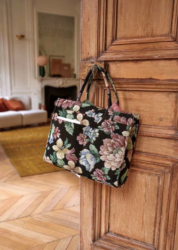 Floral tapestry tote bag made by Michelle, hanging on a door